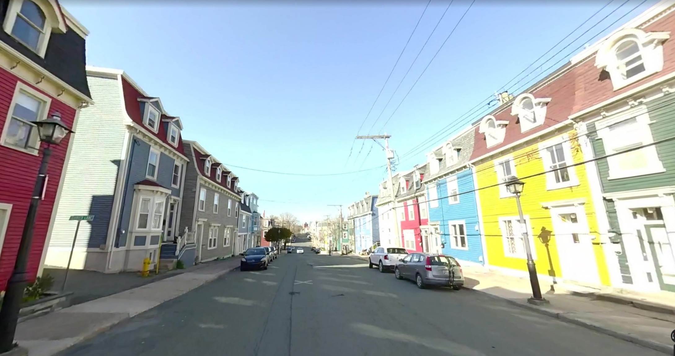 A street with cars parked on it
Description automatically generated